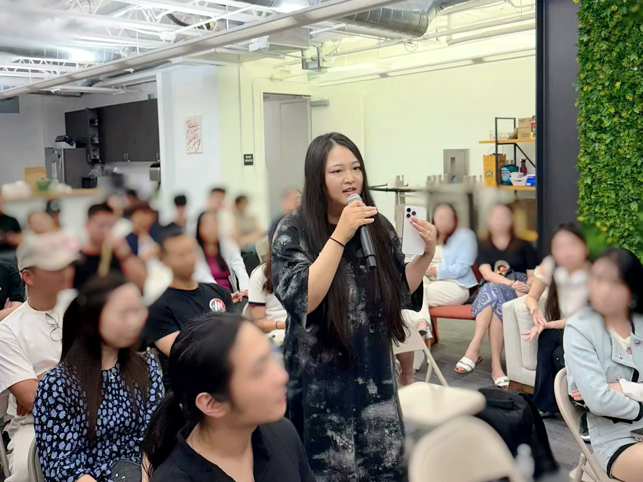 Kaitan speaking among an audience with a microphone